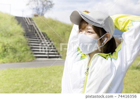 一個年輕女子在訓練中戴著口罩和深呼吸 74416356