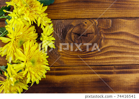 Yellow chrysanthemums on wooden background. Top view, copy space 74416541