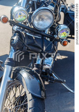 Close-up of motorcycle parked on city street Close-up of motorcycle parked on city street 74416599