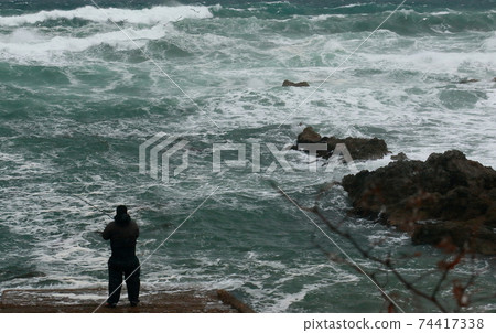 日本垂釣者冬季海大浪強風 74417338