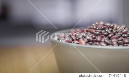 A bowl of red beans on a table on a blurred background of a window A bowl of red beans on a table on a blurred background of a window 74419448
