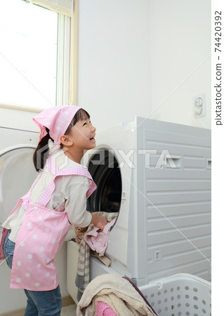 A 5-year-old girl helping to wash clothes 74420392