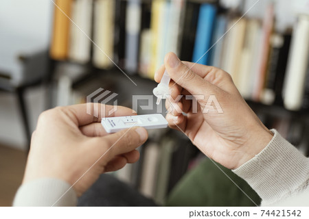 man using a covid-19 rapid antigen test at home 74421542
