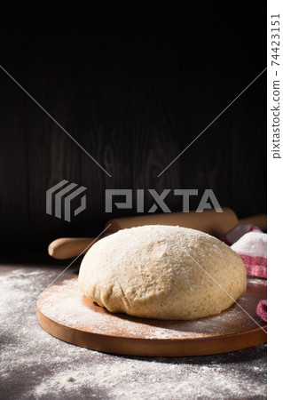 Homemade wholemeal rye wheat dough for bread on wooden table with flour, rolling-pin, dark rustic background. Homemade wholemeal rye wheat dough for bread on wooden table with flour, rolling-pin, dark rustic background. 74423151