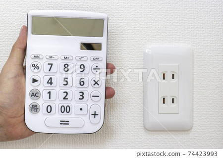 住宅牆上的插座和計算器。電費圖像 74423993