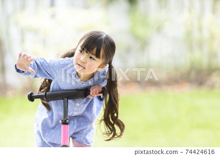 Girl riding a strider Girl riding a strider 74424616