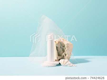 Vial bottle of cosmetic product on a podium made of natural wood blue background 74424626