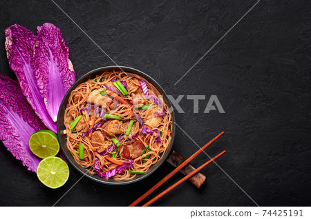 Pancit Bihon in black bowl on dark slate table top. Filipino cuisine noodles meat dish 74425191