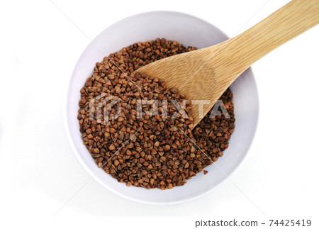 Dry buckwheat in white ceramic bowl Dry buckwheat in white ceramic bowl 74425419