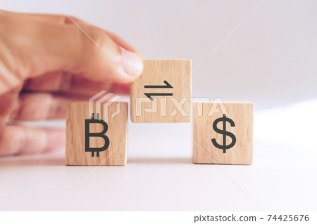 Bitcoin trade or exchange to dollar sign in stock market on wooden cube with hand hold it. Business finance future digital gold money concept. Bitcoin trade or exchange to dollar sign in stock market on wooden cube with hand hold it. Business finance future digital gold money concept. 74425676