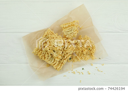Baking paper with instant noodles on white wooden background Baking paper with instant noodles on white wooden background 74426194