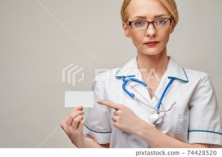 Medical worker doctor or nurse showing blank business card sign with copy space for text or design Medical worker doctor or nurse showing blank business card sign with copy space for text or design 74428520
