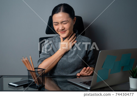 Asian woman was sick with fever, working on a laptop. Asian woman was sick with fever, working on a laptop. 74430477