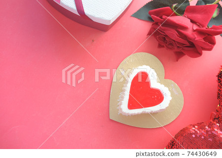 Top view of heart shape cake, gift box, and rose flower on red background Top view of heart shape cake, gift box, and rose flower on red background 74430649