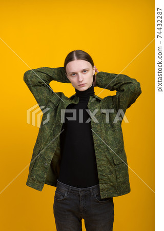 Androgen. Androgynous character on a yellow background. Man or woman. Military style. Androgen. Androgynous character on a yellow background. Man or woman. Military style. 74432287