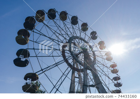 Beautiful retro colorful ferris wheel of the amusement park in the blue sky background.. 74433160