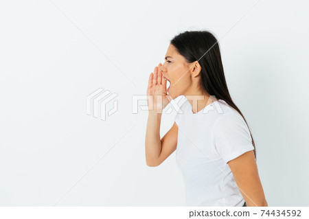 Side view studio portrait screaming young woman holding her hand 74434592