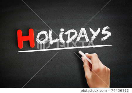 Hand writing Holidays on blackboard, holiday concept background 74436512