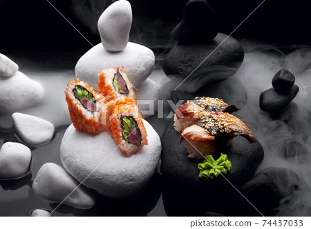 Close up of sushi nigiri with eel and sushi maki California .Sushi. On dark stone with fog . Close up of sushi nigiri with eel and sushi maki California .Sushi. On dark stone with fog . 74437033