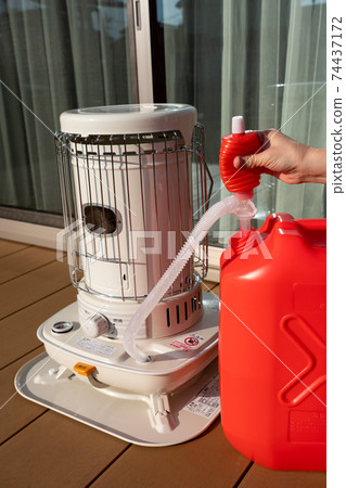 Refueling an oil stove, women's hands, winter 74437172