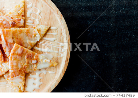 Roti with condensed milk dessert served on wooden dish. Roti with condensed milk dessert served on wooden dish. 74437489