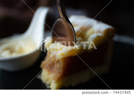 Close up of Apple Crumble Cake in dark classic cafe. 74437495