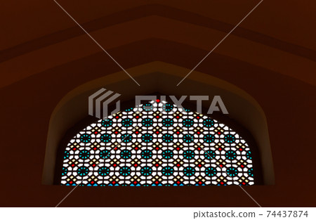 Dark wall with ancient Arabic stained glass window Dark wall with ancient Arabic stained glass window 74437874