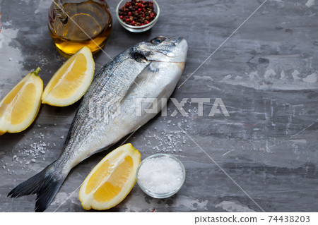raw fish with olive oil and lemon background raw fish with olive oil and lemon background 74438203