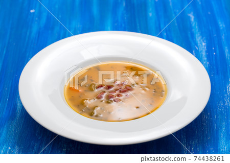 soup with smoked meat in white plate on wooden dish soup with smoked meat in white plate on wooden dish 74438261
