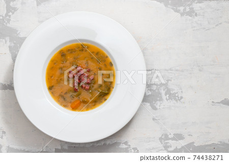 soup with smoked meat in white plate on ceramic dish 74438271