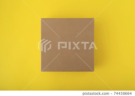 Square cardboard box on yellow background, top view. Craft box without labels. Copy space. Mock up. Square cardboard box on yellow background, top view. Craft box without labels. Copy space. Mock up. 74438664