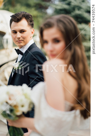 selective focus. The bride holds the groom's hand and follows him.  74439574