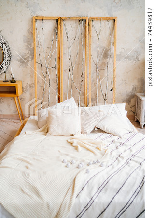 Loft interior. a bed with an unusual headboard. make-up table with a mirror Loft interior. a bed with an unusual headboard. make-up table with a mirror 74439812