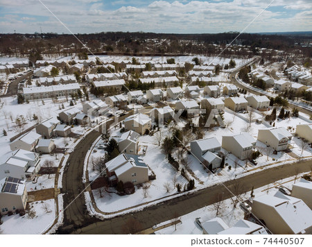 Aerial view of landscape top of the winter town residential houses with snow covered houses and roads. 74440507