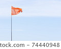 red flag on blue sky background 74440948