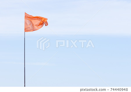 red flag on blue sky background red flag on blue sky background 74440948