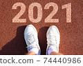 feet in sneakers on the treadmill and the inscription 2021. start of the new year, tasks, ideas, desires for the next year. 74440986
