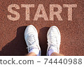 men's feet in white socks and sneakers on a sports treadmill. that says start. 74440988
