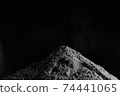 A large mountain of black earth on a black background 74441065