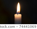 a candle burns with fire on a black background 74441069