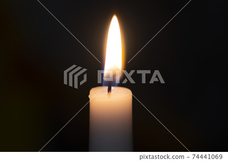 a candle burns with fire on a black background 74441069
