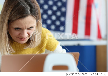 Woman works on computer in background hanging an American flag 74441732