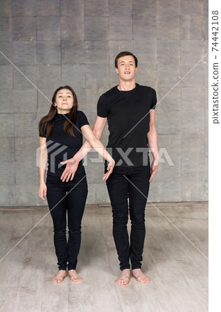 Couple of dancers posing on grey background. 74442108