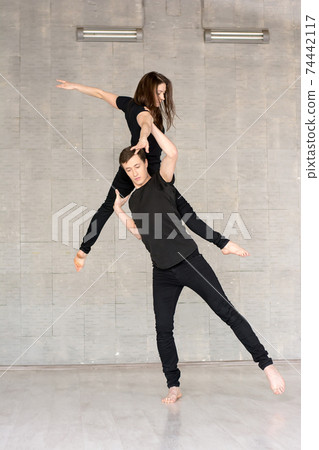 Young couple practices acrobatic balance. 74442117
