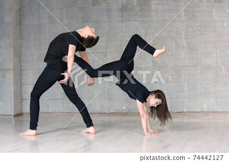 Young couple make acrobatic element. 74442127
