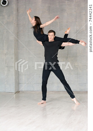 Couple in black dancing, grey background. 74442141