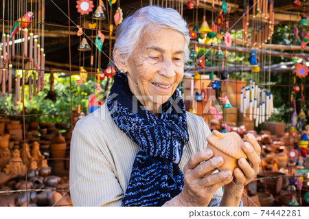 Senior woman buying pottery at a traditional ceramics factory in the city of Raquira. City of Pots Senior woman buying pottery at a traditional ceramics factory in the city of Raquira. City of Pots 74442281