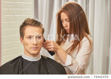Young female barber at work. Young female barber at work. 74442470
