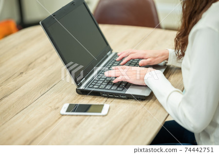 A middle-aged woman who uses a personal computer during her self-restraint A middle-aged woman who uses a personal computer during her self-restraint 74442751