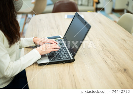 A middle-aged woman who uses a personal computer during her self-restraint A middle-aged woman who uses a personal computer during her self-restraint 74442753